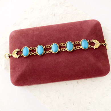 bracelet with vintage turquoise blue glass moonstone links displayed on a plum velvet jewellery box