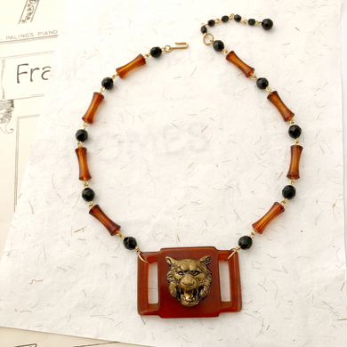 necklace with plastic belt buckle embellished with roaring tiger's head and vintage black and faux tortoiseshell beads