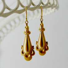 Load image into Gallery viewer, gold drop earrings with scrolled edges hanging from a wir4e frame
