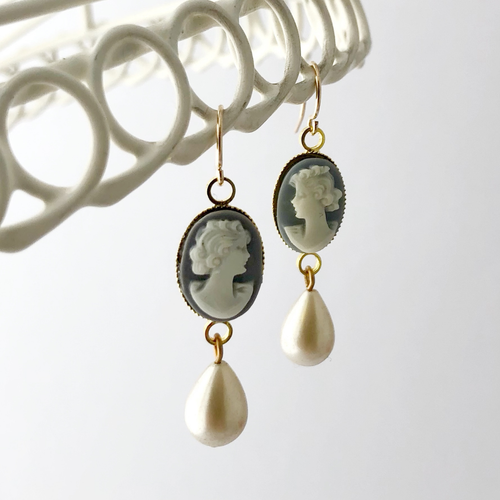 Blue cameo earrings with pearl drops on a white background