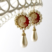 Load image into Gallery viewer, Pair of earrings with vintage cameos and pearls hanging against a white background
