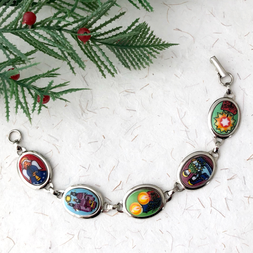 Bracelet with colorful Christmas images and vintage Christmas tree branch against a white background