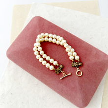 Load image into Gallery viewer, double stranded pearl bracelet displayed on a pink velvet jewellery box

