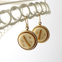 Load image into Gallery viewer, Gold earrings with clarinet and music notes design hanging against a white background
