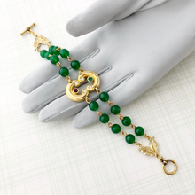 Load image into Gallery viewer, bracelet with gold focal and two strands of emerald Lucite beads displayed on a gloved hand
