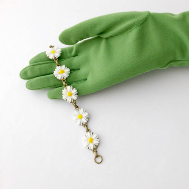 bracelet with vintage plastic daisies displayed on a gloved hand