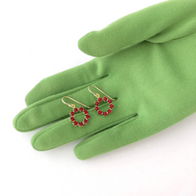 Load image into Gallery viewer, vintage red Swarovski rhinestone circle earrings ispalyed on a green gloved hand
