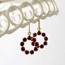 Load image into Gallery viewer, vintage red Swarovski rhinestone circle earrings hanging from a white frame
