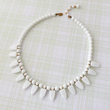 Load image into Gallery viewer, a necklace of repurposed vintage milk glass beads displayed flat on a faint checked background
