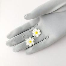 Load image into Gallery viewer, earrings made with vintage plastic daisies displayed on a gloved hand
